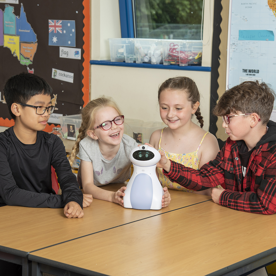 Young children in a classroom coding with oti-bot